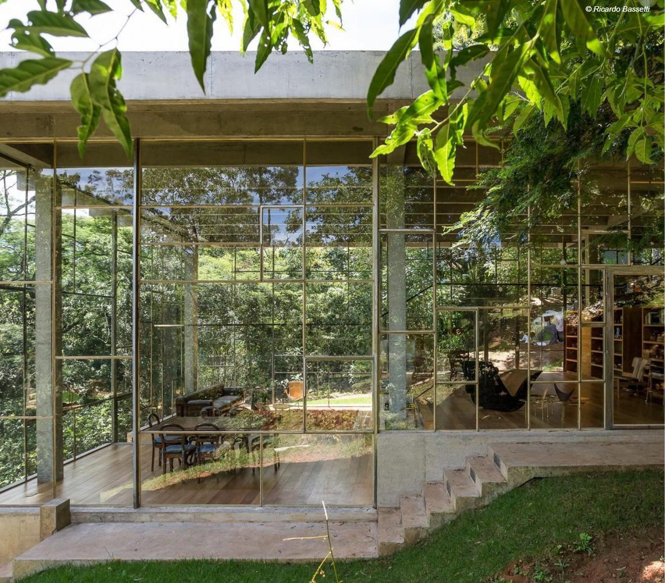 Fachada envidraçada da Casa Biblioteca em Vinhedo, cercada por Mata Atlântica